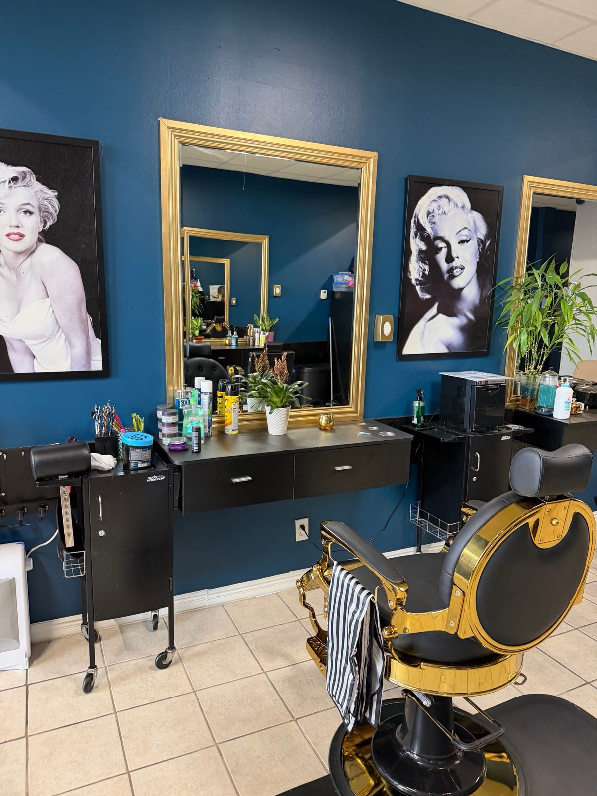 Salón con pared azul, espejos de marco dorado y cuadros de Marilyn Monroe